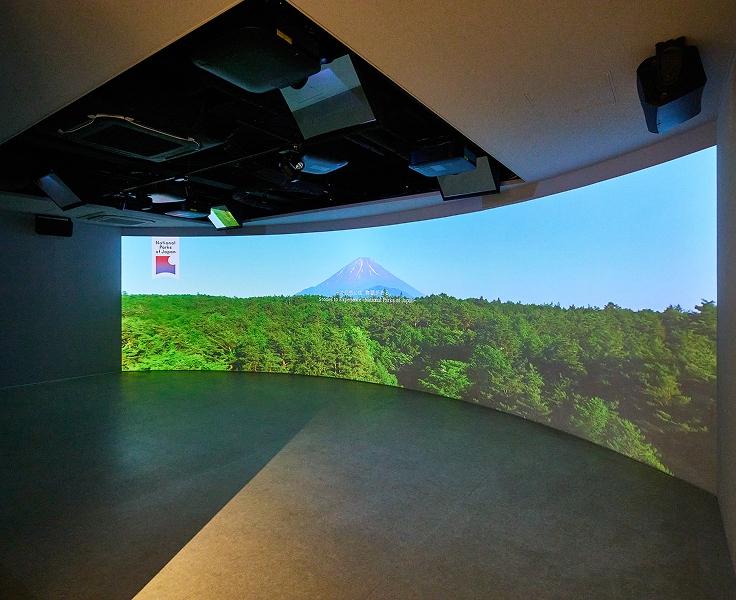 [写真]新宿御苑インフォメーションセンター内のシアターの様子。スクリーンには、国立公園の雄大な映像が映し出されています。
