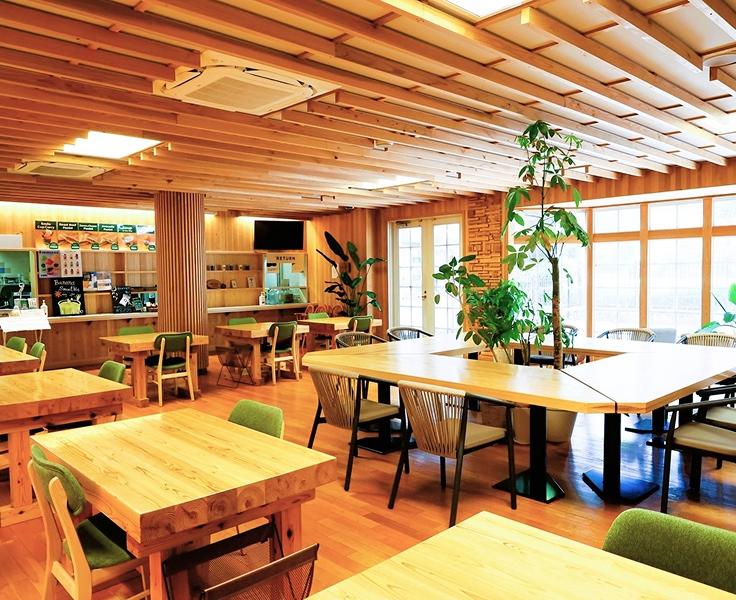 [写真]NATIONAL PARKS CAFÉ Under the Treeの座席です。床や天井、家具にいたるまで木材がふんだんに使われており、木のぬくもりを感じられる柔らかな雰囲気の店内です。
