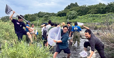 川で生き物を調べる人々