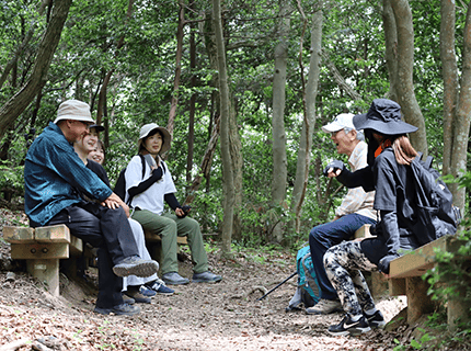 画像：和歌山大学観光学部の学生がボランティアガイドの方々と一緒に、俎石山ハイキングコースを散策している様子