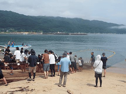 画像：地引綱を参加者が全員で協力して引っ張っている様子